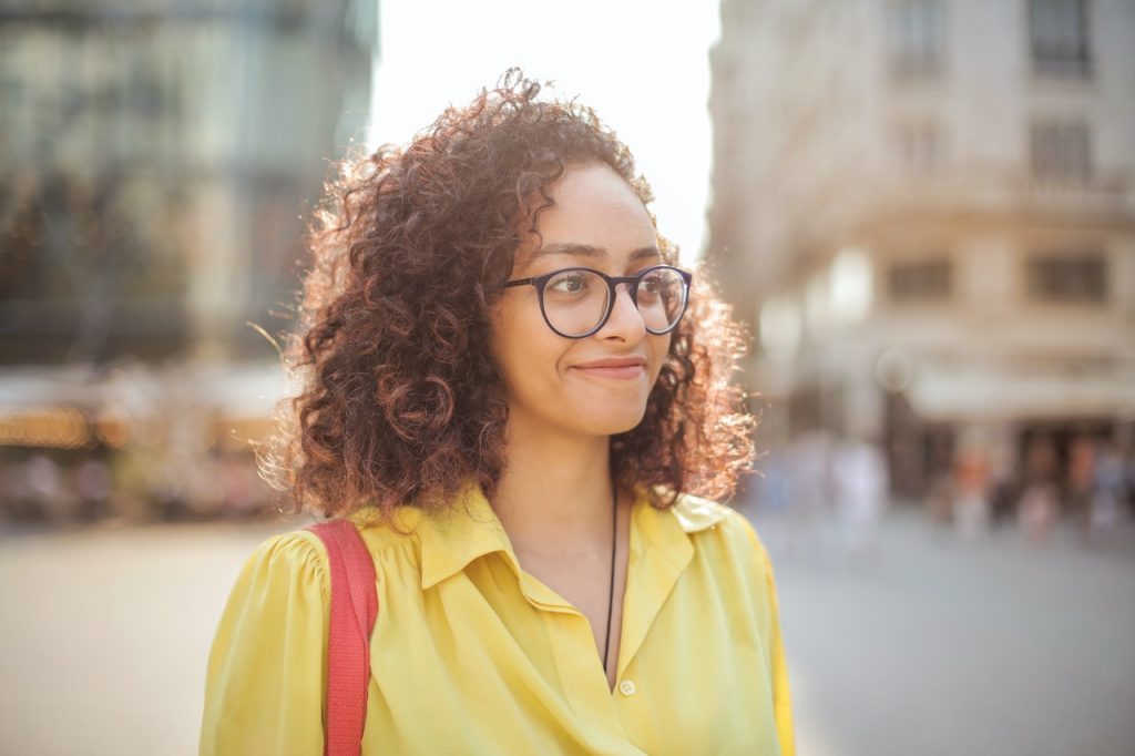 Smiling girl wearing eyeglasses and a yellow blouse -Total Vision and Hearing in Ancaster, Ontario